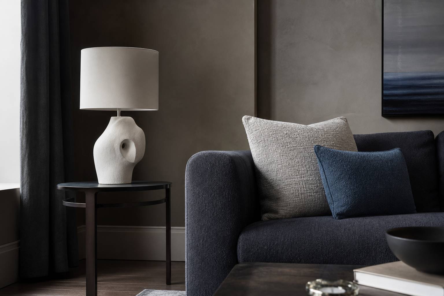 Coin déco chic avec lampe design et coussins texturés dans un intérieur contemporain